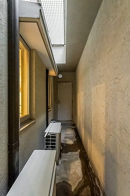 ドライエリアを奥に進むと、室外機のさらに奥に扉を発見！ 扉の中は大容量のトランクルームになっており、幅を取る大きな物でも収納可能です。こちらは月額1，500円で住戸に付帯します。