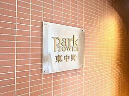 「Park TOWER 東中野」の看板が、洗練されたデザインで住まいの顔を飾ります。温かみのあるレンガ調の外壁が、家族の毎日を優しく包み込む上質な暮らしを予感させます。