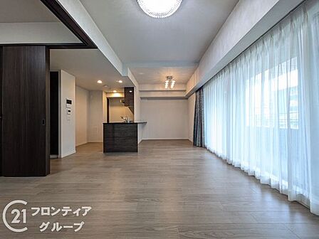 大きな開口部から柔らかな光が差し込むリビングは、開放感に満ちた心地よい空間です。洗練されたインテリアが映えるフラットな設計が、家族が集うひとときをより豊かで上質なものへと導きます