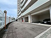 建物の1階部分に設けられた駐車場です。上部が覆われているため、雨天時でも濡れずに車の乗り降りや荷物の積み下ろしがしやすい構造です。前面の通路幅にもゆとりがあり、落ち着いて駐車作業が行えます。