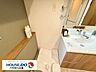 室内：洗面台の横に設置された便利な洗濯機置場。側面には洗剤や柔軟剤をサッと置ける木目調のカウンター棚を配置しています。家事動線が良く、洗面周りの整理整頓もしやすい使い勝手に優れたスペースです。
