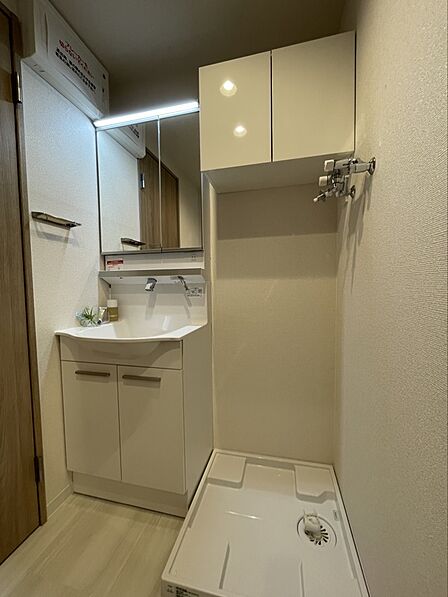 洗面所には可動棚の収納スペースがあり、タオルや洗剤、ストック用品を効率よく収納できます。洗濯機置場も隣接しており、スムーズな家事動線を実現。すっきりと片付いた洗面空間をキープできます