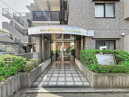 手入れされた植栽が彩るアプローチ。屋根付きで雨の日の移動もスムーズです。