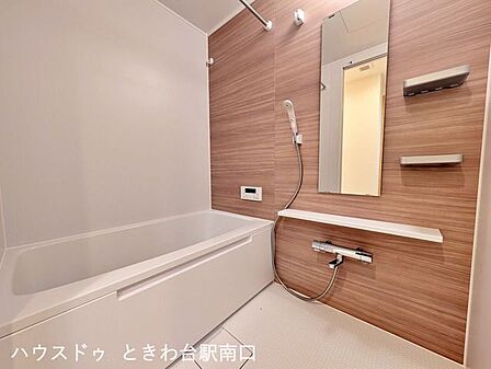追い焚き・浴室乾燥機を完備した新品のバスルーム。木目調のアクセントパネルが落ち着いた雰囲気を演出し、一日の疲れを癒せます。