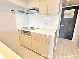 三口コンロを備えたシステムキッチンは、効率的な動線を確保しています。吊戸棚もあり収納力が高く、調理器具や調味料をスマートに整理できる実用的な仕様です。