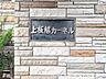 外観：重厚な石壁に設置された館名板。建物の顔として、落ち着いた風格を漂わせています。