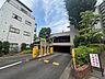 駐車場：緑豊かな植栽に囲まれ、落ち着いた環境が保たれた敷地内の入り口風景です。