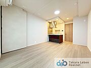 ナチュラルな木目調の床から木のぬくもりを感じられる広々としたリビングルーム。