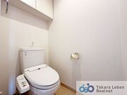 白を基調とした清潔感のあるトイレ。上部に収納もついておりますので、とても便利です。