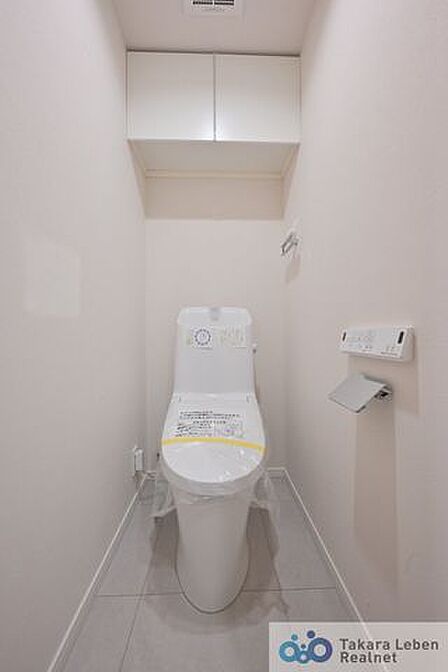 白を基調とした清潔感のあるトイレ。上部に収納もついておりますので、とても便利です。