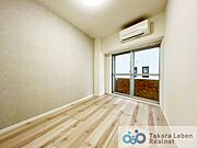 洋室約4.8帖：大きな掃き出し窓から採光が隅々まで行き渡る明るい空間です。