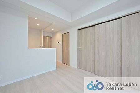 ナチュラルな木目調の床から木のぬくもりを感じられる広々としたリビングルーム。