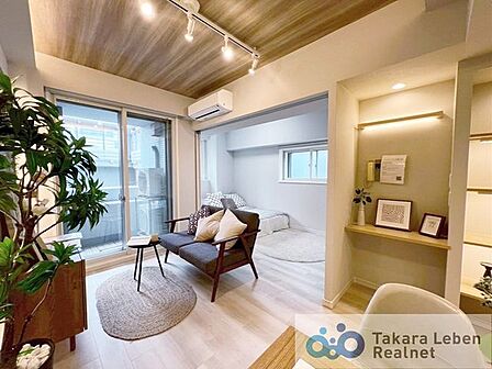 ナチュラルな木目調の床から木のぬくもりを感じられる広々としたリビングルーム。