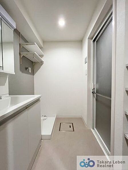鏡裏にも収納可能な三面鏡洗面化粧台。洗濯機置き場上部に、ハンガーパイプ付き吊戸棚がございます。