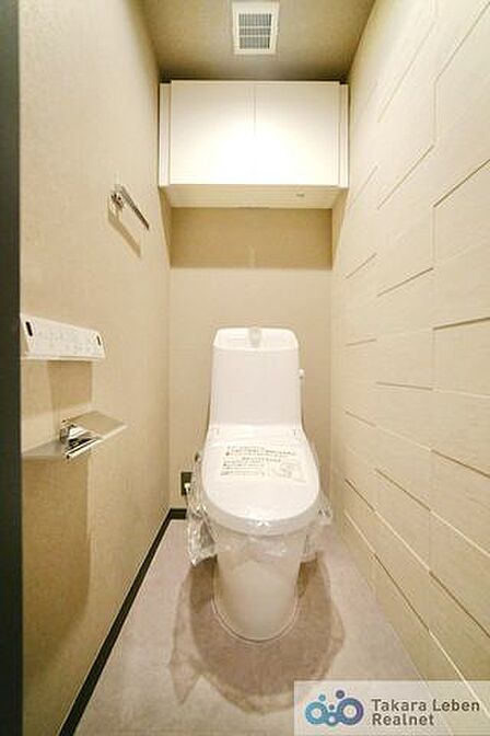 ウォシュレット機能付きのトイレは壁掛けリモコンの上位グレードを採用。便座がスッキリした印象となり、限られた空間を広く見せる効果があります。