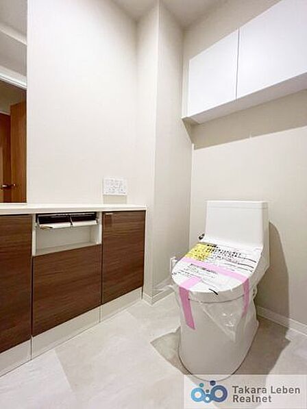 ウォシュレット機能付きのトイレは壁掛けリモコンの上位グレードを採用。便座がスッキリした印象となり、限られた空間を広く見せる効果があります。