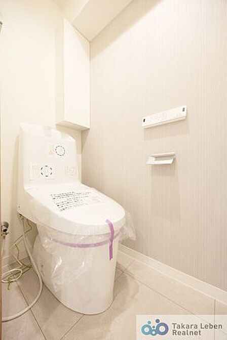 ウォシュレット機能付きのトイレは壁掛けリモコンの上位グレードを採用。便座がスッキリした印象となり、限られた空間を広く見せる効果があります。