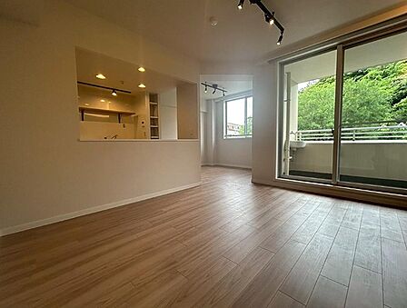 明るい木目調のフローリングが広がるリビング。窓の外に広がる豊かな緑が、お部屋に開放感をもたらします。