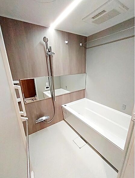 明るい照明と、アクセントクロスが配された落ち着いた雰囲気の浴室。一日の疲れを癒すバスタイムをお過ごしください。浴室乾燥機や物干しバーもあり、機能性も兼ね備えています。