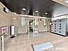 エントランス：落ち着いた色合いでまとめられたマンションエントランス。屋根付きで、雨の日も出入りしやすい快適な共用スペースです。