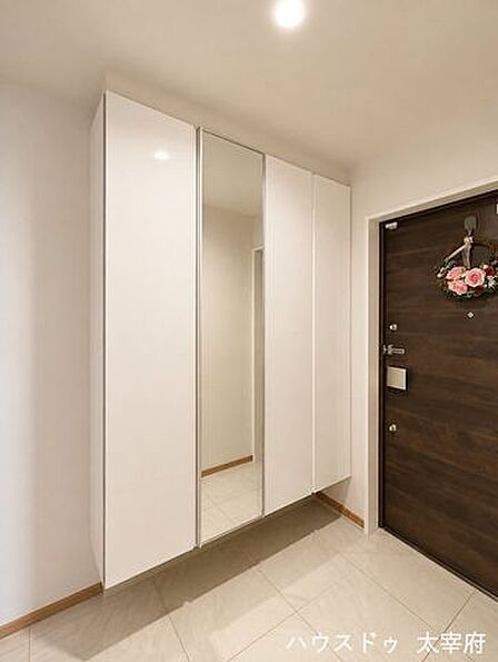 天井まで届く大型収納付きで、生活感を抑えたホテルライクな玄関空間。落ち着いた色合いと直線的なデザインが、洗練された印象の玄関です。※AIによる画像加工を行っています。現況を優先いたします。