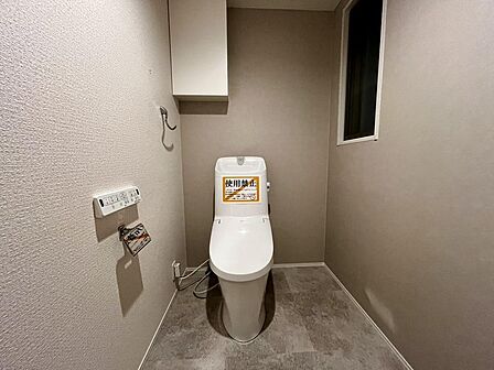 シンプルで清潔感のあるトイレ空間。落ち着いたアクセントクロスが上品な印象です。