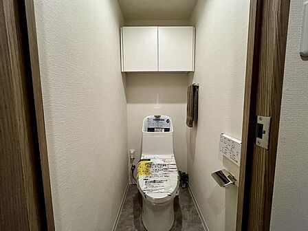 温水洗浄便座付きトイレ。上部収納も備えた使い勝手の良い空間です。