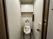 温水洗浄便座付きトイレ。上部収納も備えた使い勝手の良い空間です。