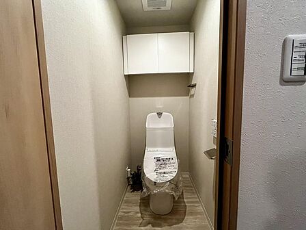 温水洗浄便座付きトイレ。上部収納も備え、すっきりとした空間を保てます。