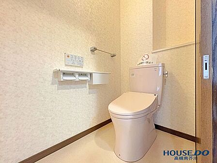 清潔感あふれる温水洗浄便座付きのトイレ。背面にはトイレットペーパーなどを隠して収納できる便利な戸棚を完備。手すりも設置されており安心です。
