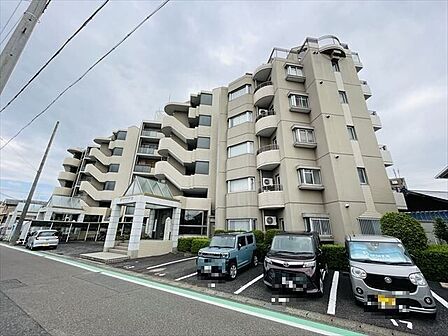 明るいベージュの落ち着いたアースカラーの外観です。