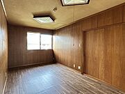 【洋室】約9帖。板張りの壁が落ち着いた印象の洋室。