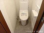 清潔感のあるシャワートイレを採用しています。上部にはトイレットペーパーや清掃用品の保管に便利な棚を備え、日常の使い勝手に配慮された空間です。