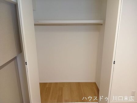 衣類をシワなく保管できるハンガーパイプと上部棚を備えたクローゼット。機能的な収納力で、居住空間をすっきりと保ちます。