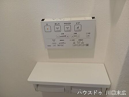 快適な使い心地を提供する温水洗浄便座の操作パネル。ちょっとした小物を置くことができる棚付きのペーパーホルダーを設置。