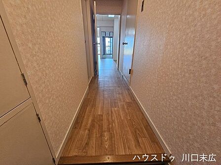 居住空間へと繋がる玄関スペース。上がり框の木目が温かみを感じさせ、帰宅したご家族や訪れるゲストを優しく迎え入れる、落ち着きのあるエントランスです。