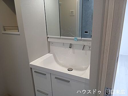 広々とした洗面ボウルを備えた洗面化粧台。水栓が壁面に設置されているため水が溜まりにくく、清潔なサニタリー空間をスマートに保ちます。