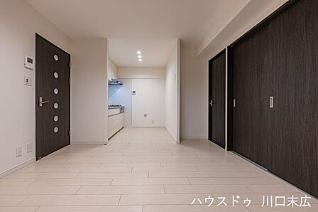 キッチンから居室へと続くスムーズな動線が確保され、家事の並行作業も快適にこなせます。フローリングの明るい色調が、インテリアの幅を広げます。