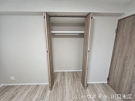 開口部が大きく使いやすい折れ戸式クローゼット。ハンガーパイプと枕棚を備え、衣類や荷物を綺麗に収納できます。