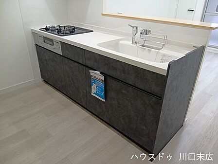 シックな面材がお洒落なシステムキッチン。広々としたワークトップを備えており、調理器具や食器類を整理しながら効率良く毎日の家事をこなせる機能的な設計です。