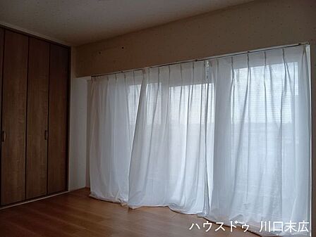 大きな掃き出し窓を備えた洋室です。フローリング仕様で掃除がしやすく、家具の配置もしやすい整形空間ですので、寝室として最適です。