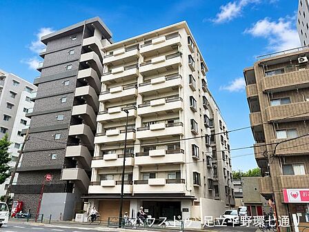 重厚感のあるタイル張りの外観が印象的なマンション。大通り沿いで視認性も良く、周辺には商業施設や交通機関も揃い、生活利便性の高い立地です。