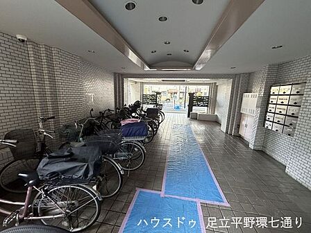タイル張りで清潔感のあるエントランス空間。屋根付きで雨の日でも安心して出入りでき、集合ポストも設置された管理の行き届いた共用部です。