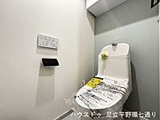 温水洗浄機能付きトイレ。アクセントクロスが空間に落ち着きと清潔感を添えています。