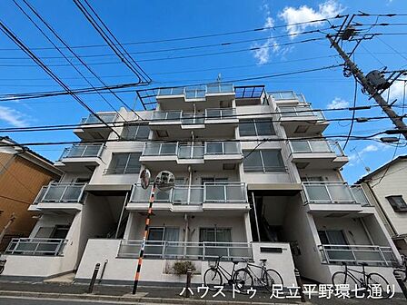 落ち着いた住宅街に佇む、明るく開放感のある外観。バルコニーが整然と配置された、すっきりとした印象のマンションです。