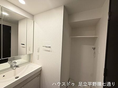 三面鏡付き洗面化粧台と洗濯機置場をまとめ、身支度や家事がしやすい洗面室です。