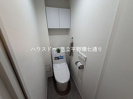 温水洗浄便座付きの清潔感あふれるトイレ。上部収納付きで生活感をすっきり隠せます。