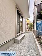 家の側面には砂利を敷き詰め、防犯面と排水性に配慮しました。掃き出し窓の下にはステップを設置し、庭先への出入りも容易です。隣地との境界もしっかり管理されており、すっきりとした景観を保っています。