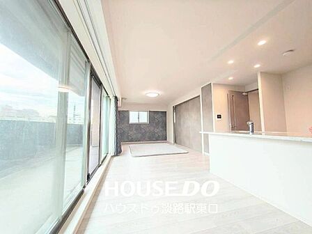 自然光がたっぷりと差し込む広々としたリビングです。キッチンから部屋全体を見渡せるので、調理中も家族との会話が弾みます。温かみのある床材と落ち着いたアクセントクロスが、リラックスできる空間を演出します。