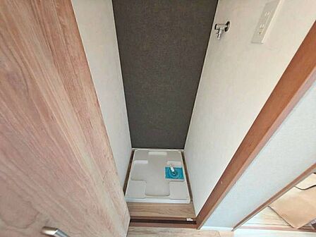 シックなアクセントクロスが印象的な洗濯機置き場スペース。専用の防水パンと給水栓を完備しています。